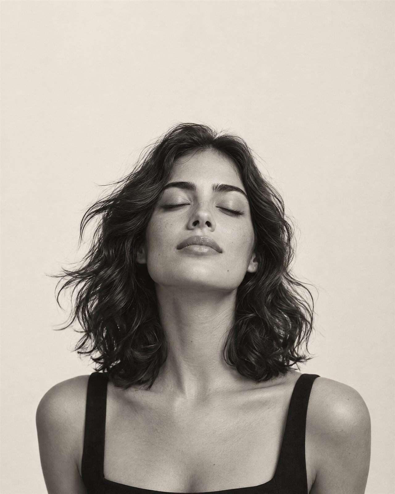 Black and white portrait of a woman with her eyes closed, head tilted up